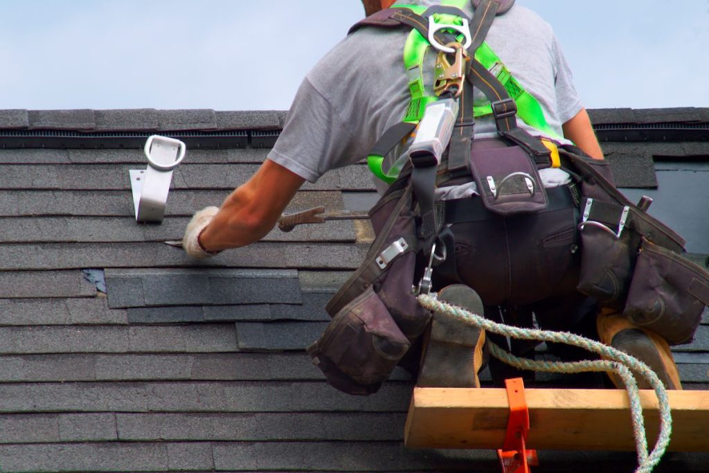 roofer repairing asphalt shingles
